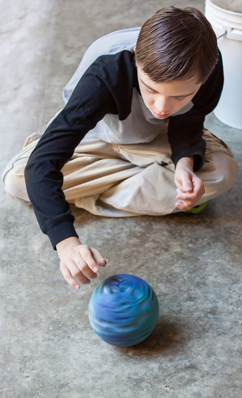 Student with Autism spinning ball on floor