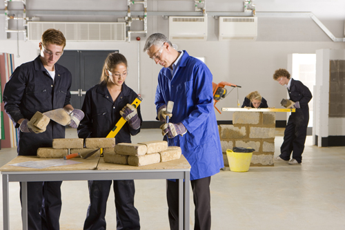 Students working with instructor at construction job site