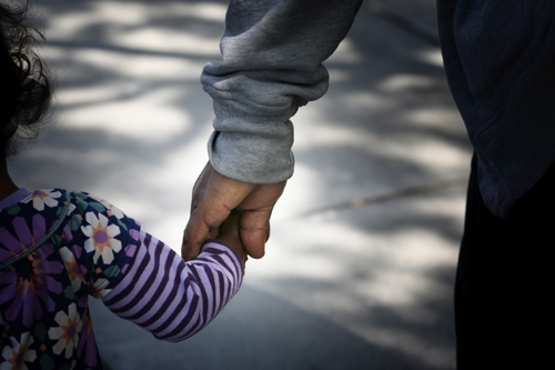 child and adult holding hands