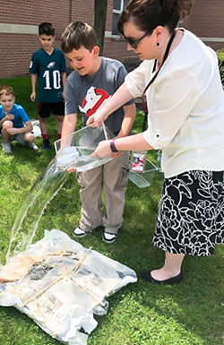 Student and teacher outdoors with water activity