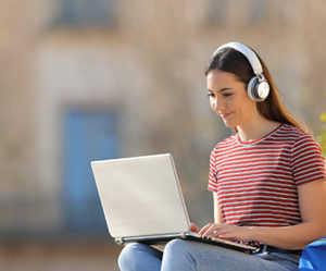 teen working on laptop outside