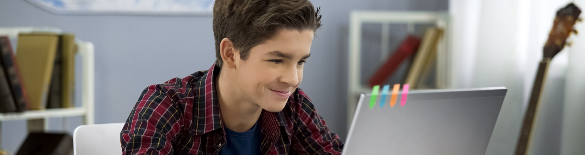 Engaged teen working on laptop