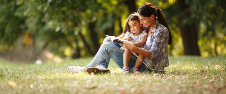 mother and daughter reading in a park