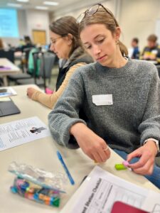 Woman at a conference table piecing together Lego blocks