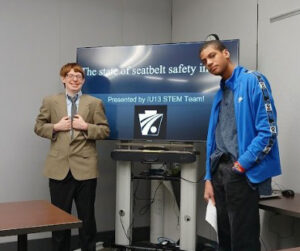 Students smiling in front of presentation
