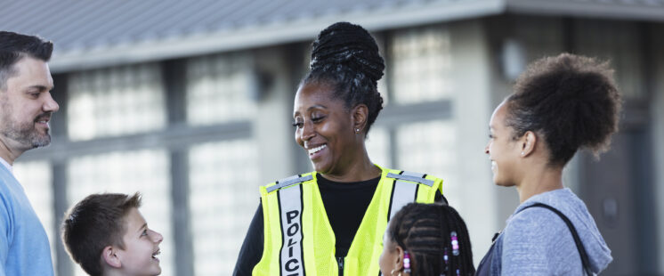 Smiling policewoman talking with families.