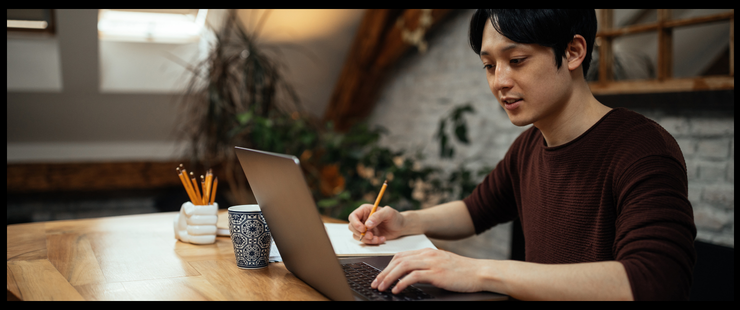 Young man working on computer at his dining table