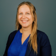 Smiling Aura Heisey in blue shirt and navy blue blazer