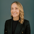 Smiling Lauren Miller in black shirt and black blazer