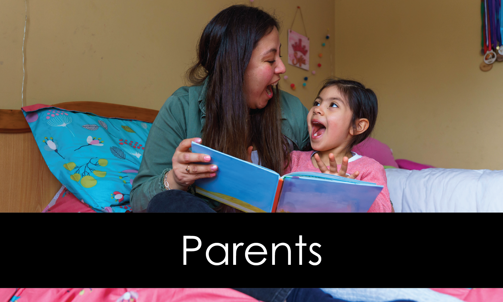 Mother and daughter having fun reading a book together in the child's bedroom.