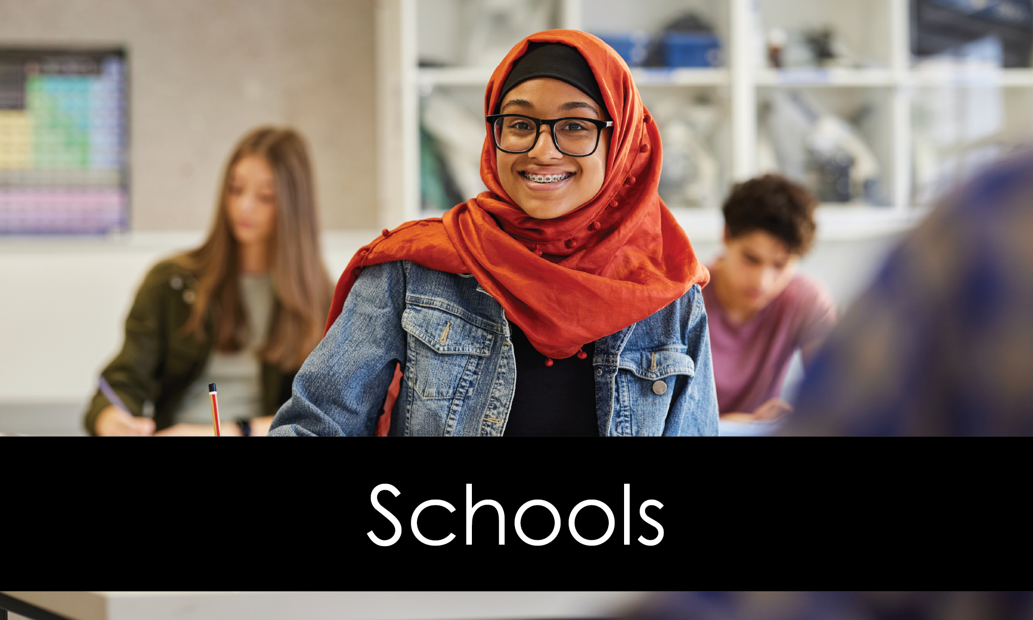 Smiling Muslim teen working in a classroom